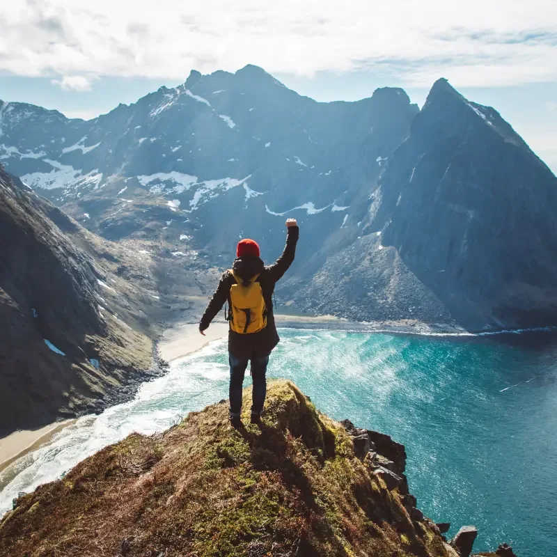 A person overlooking a mountain landscape after reaching the summit